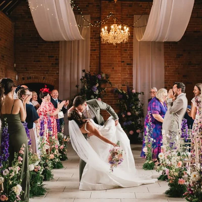 A couple mid-dip in a barn ceremony