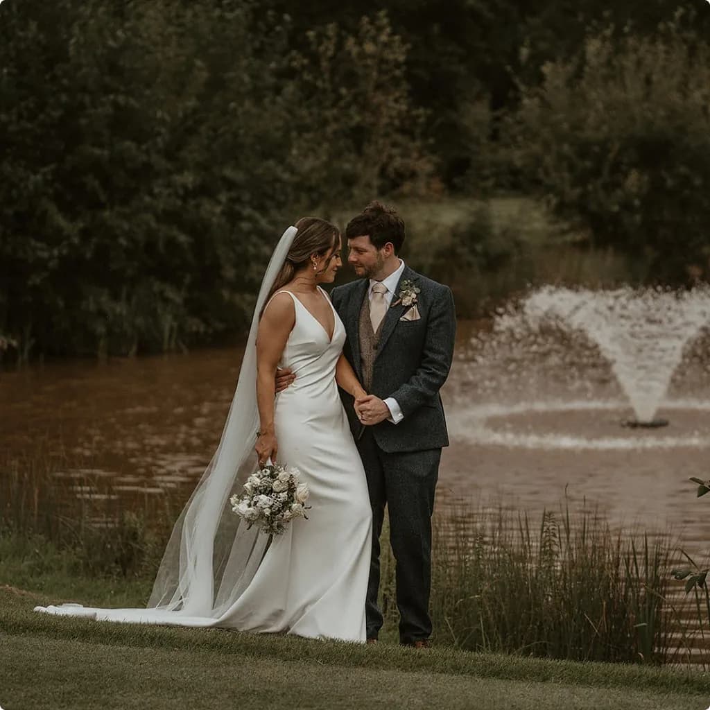 A couple beside the lake at a country wedding venue